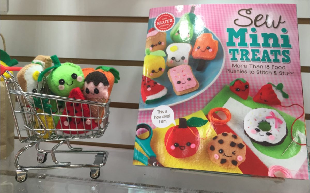 mini food plushies in mini shopping cart next to mini plushie sewing kit