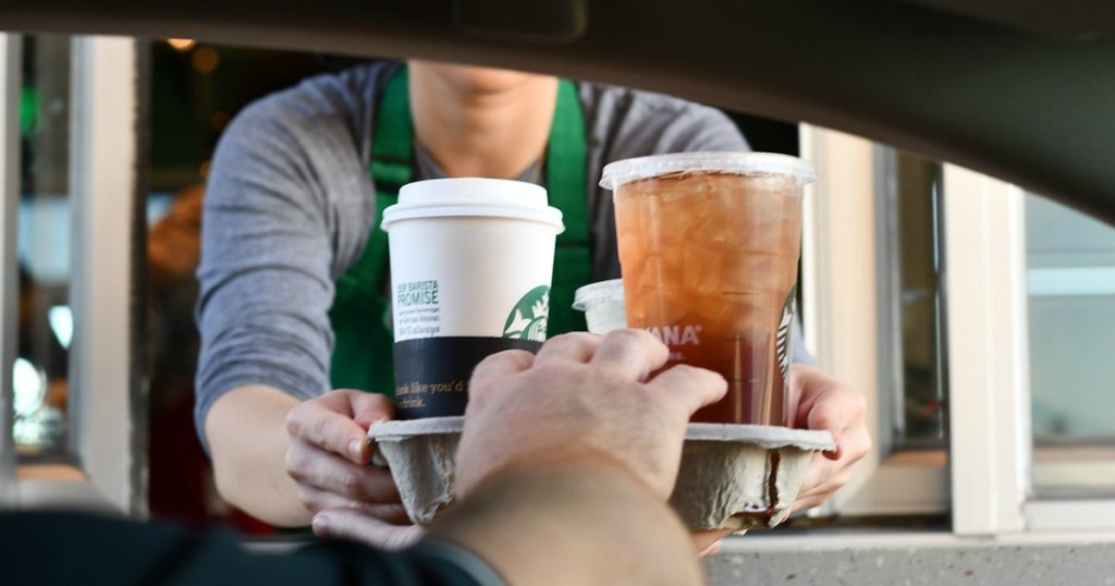 Starbucks employees handing out drinks through the drive through