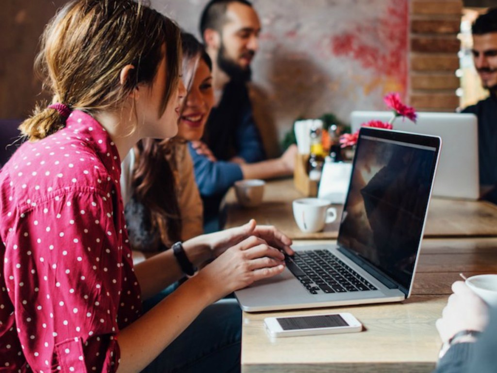 Men and women sitting in a coffee shop on their computers