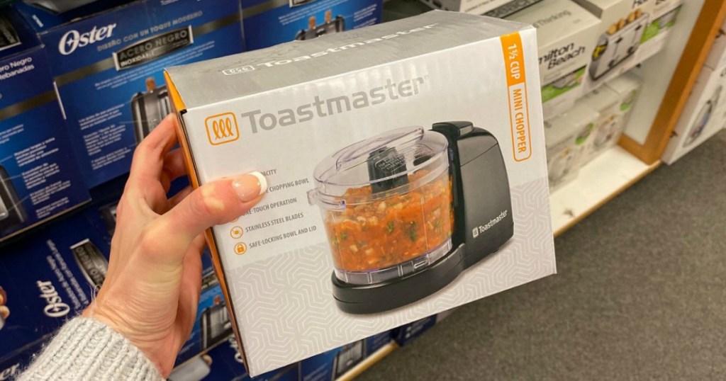 Woman's hand holding a Toastmaster brand toaster in package near in-store display