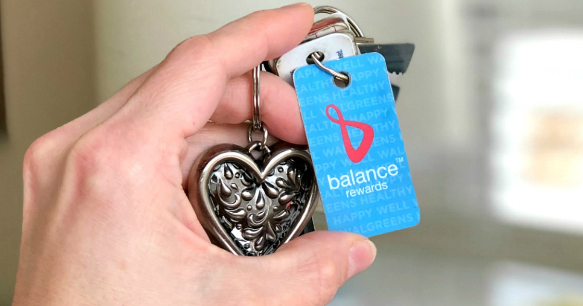 Woman holding Walgreens balance rewards card on keychain