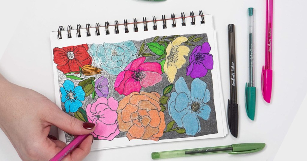 hand holding pink Zebra Pen Doodlerz coloring flowers