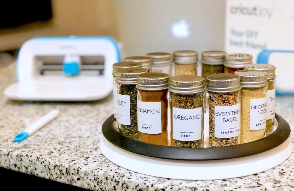 white and black lazy susan holding matching labeled spices on granite counter