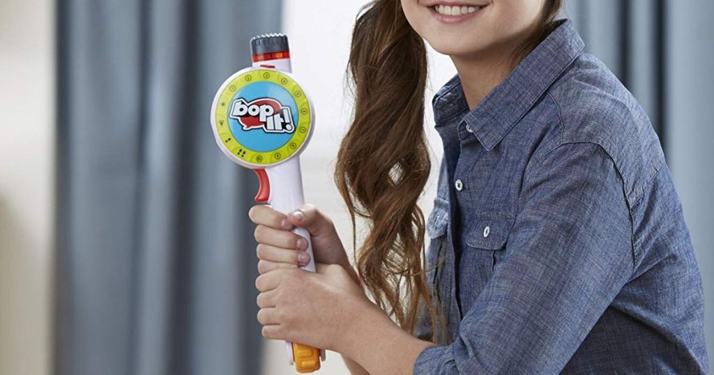 girl holding bop it maker game like a bat