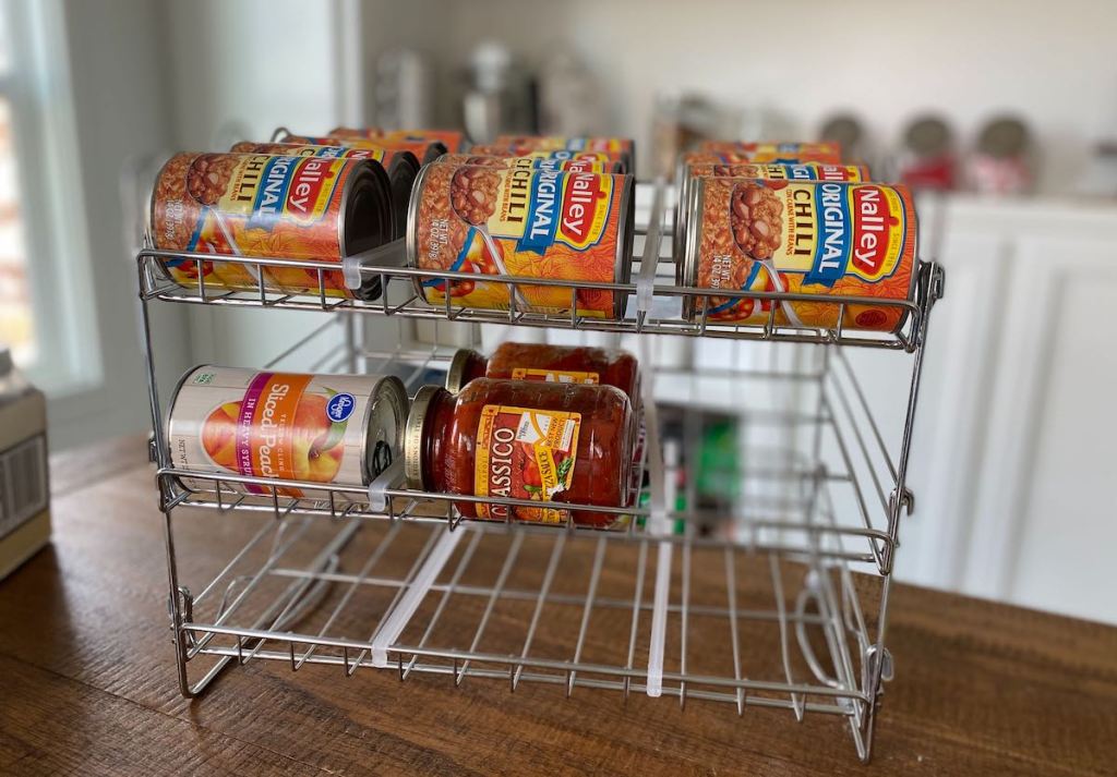 metal can rack on wood table with jars and cans of food