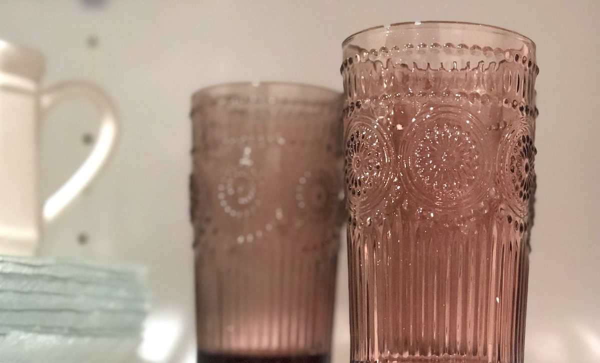 vintage purple pink drinking glasses sitting inside of cabinet with other dishes