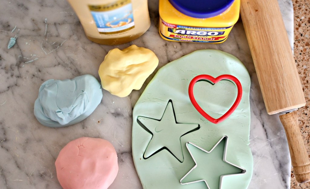 homemade play-dough on a cutting board with cookie cutters