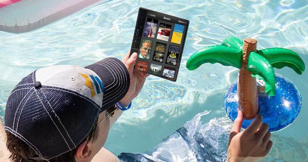 man holding a kindle ereader next to a pool