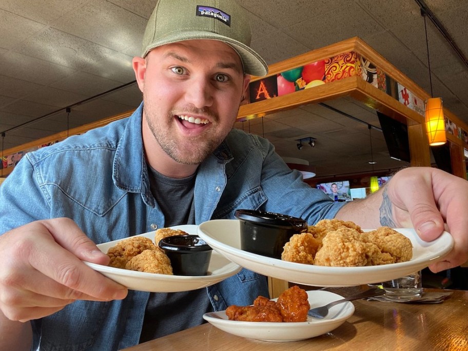 Man holding plats of Boneless Wings at Applebees