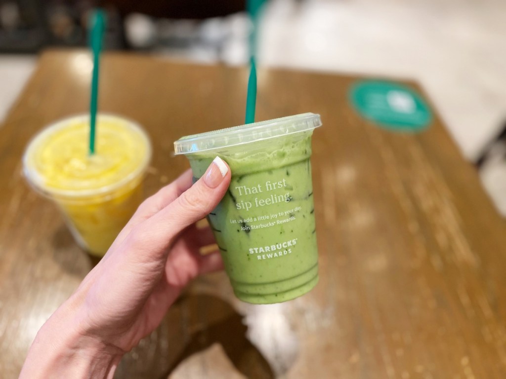 hand holding green cold drink at Starbucks