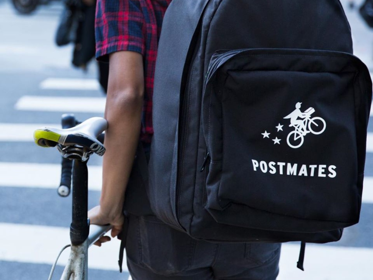 Man wearing Postmates backpack with bike