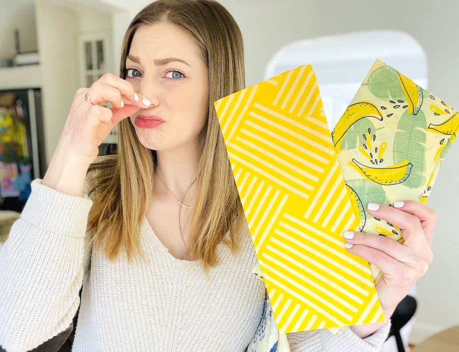 woman with fingers pinching nose while holding bright yellow wax bags