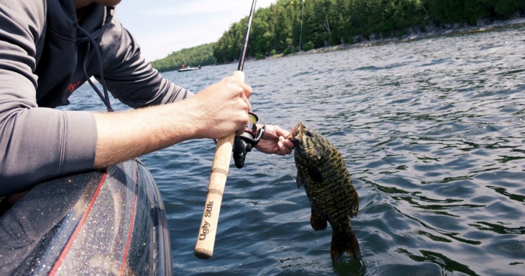 man holding fishing rod on water with fish