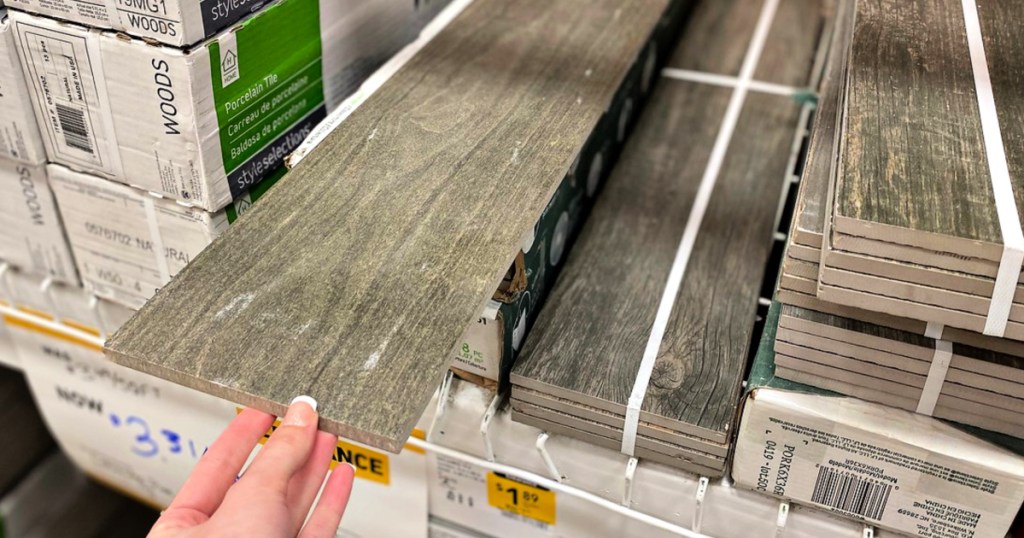 woman holding piece of tile at lowes