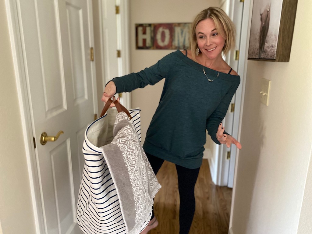 woman holding laundry basket with towel inside 