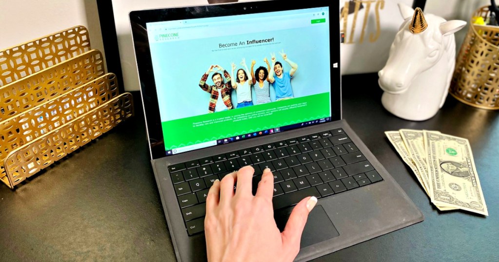 woman on laptop with $3 on desk