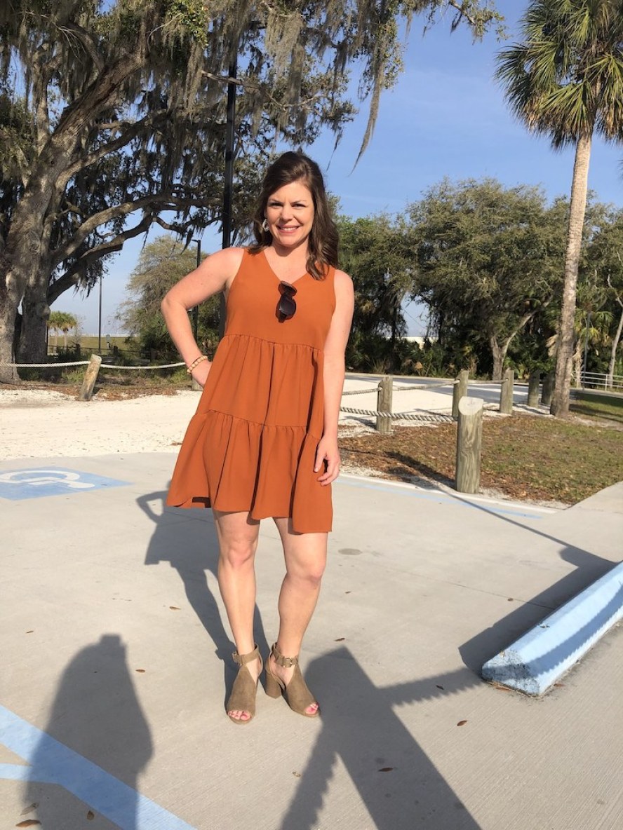 woman wearing orange dress with heels outside 