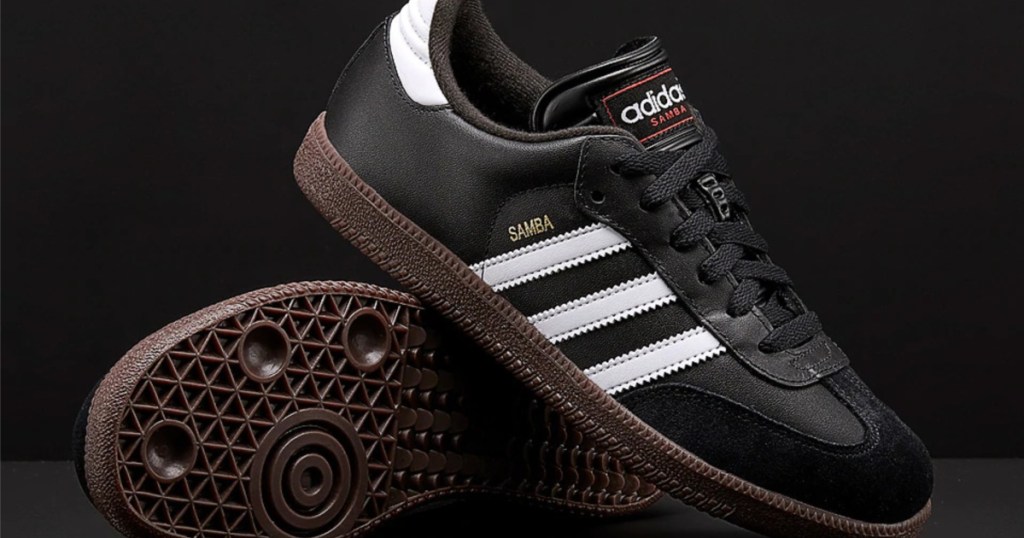 kids black Adidas soccer shoes and black background