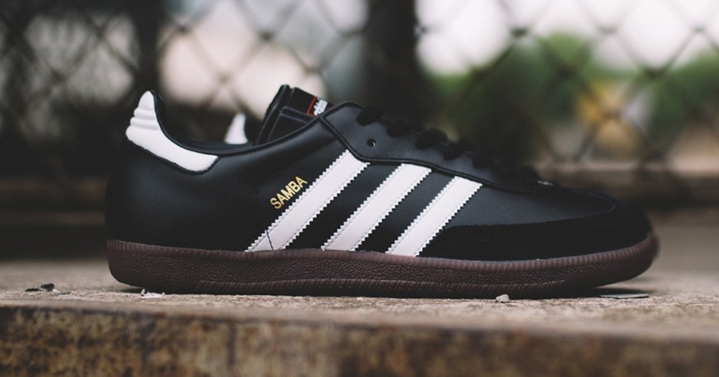 black Adidas soccer shoes on ledge outside