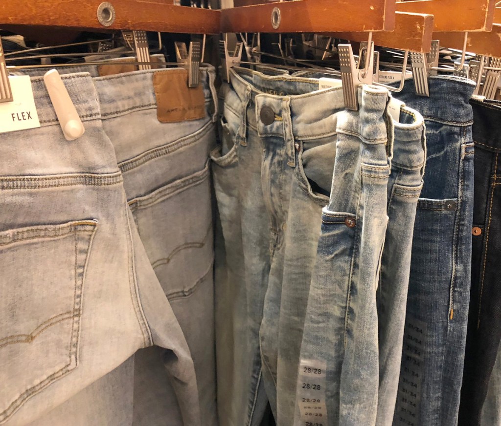 store display of different washes of mens jeans on hangers