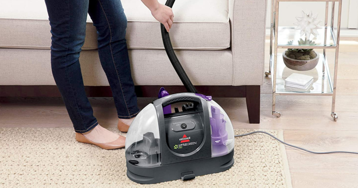 woman using pet vacuum cleaner in home