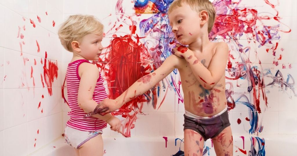 Two kids painting in bathtub