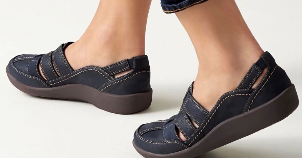 woman's feet wearing flat sandal type shoes