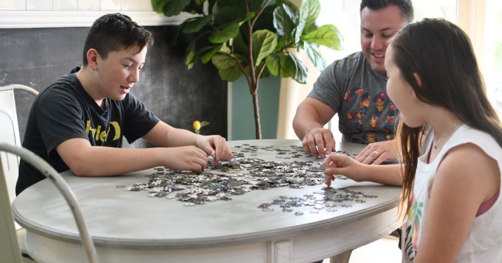 Family sitting at kitchen table doing a puzzle together