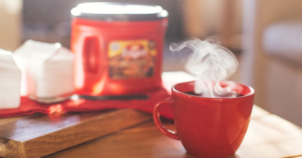 cup of coffee and coffee canister on wood table in home