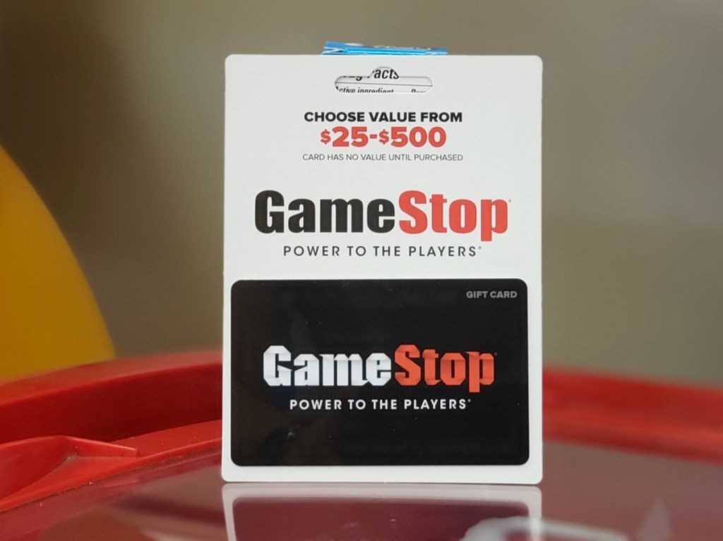 GameStop gift card standing on red table