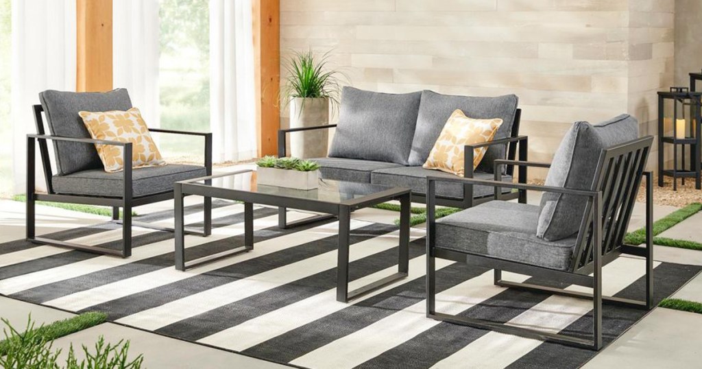 grey 4 piece patio set with black steel frame on a black and white striped rug