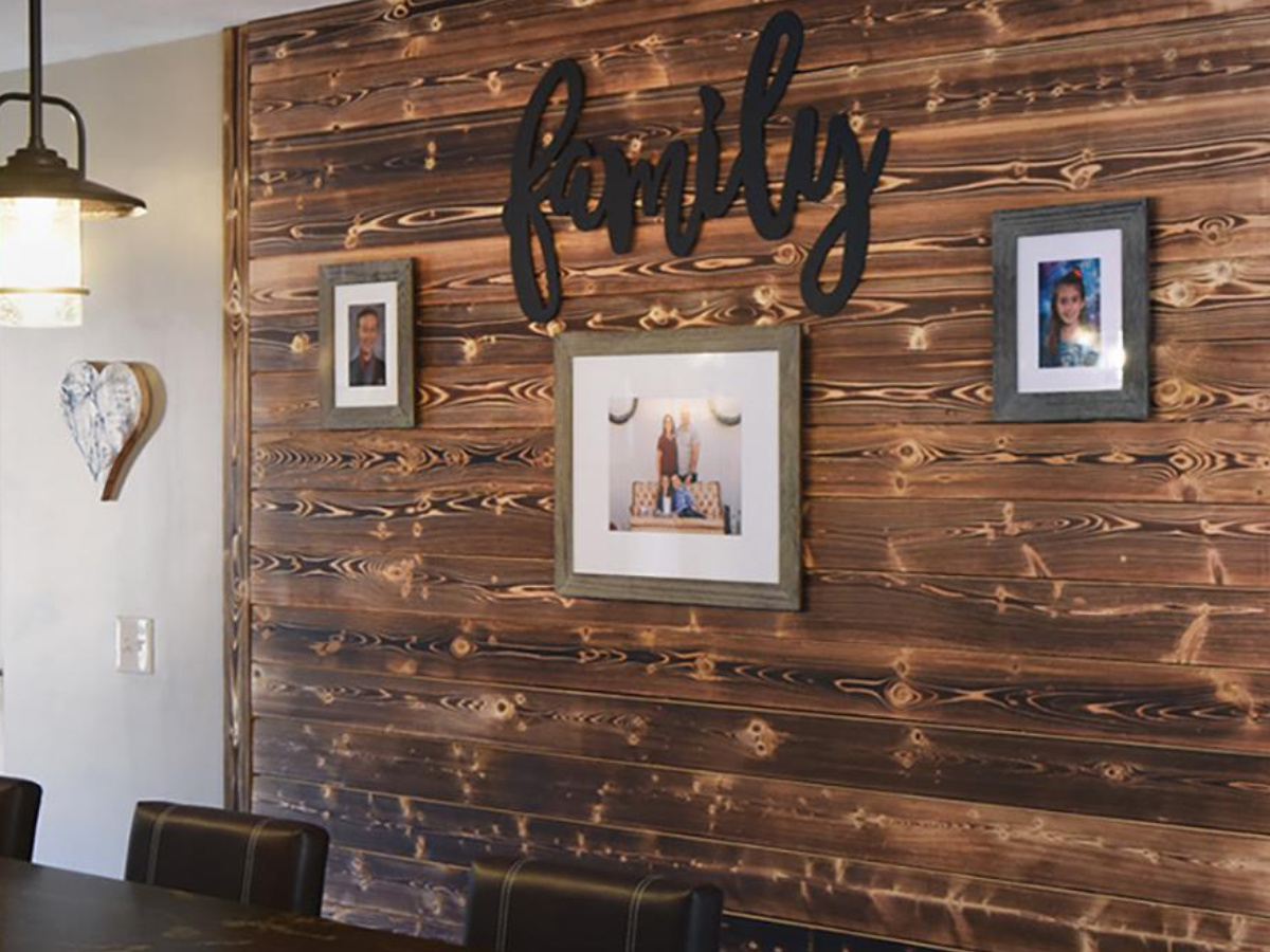 Large wall with shiplap detail with "family" sign and picture frames