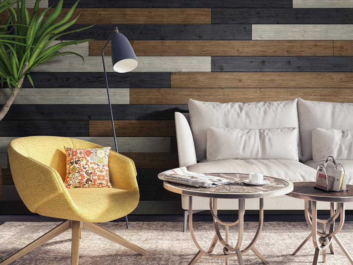 wall finished with dark shiplap boards in living room near sofa, arm chair, and lamp