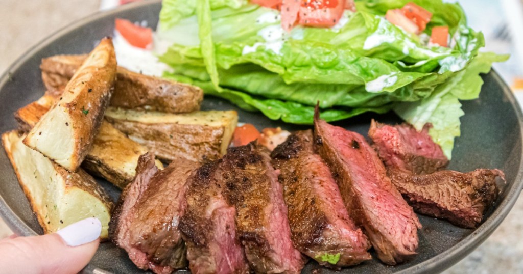 plate with steak, potatoes and a salad