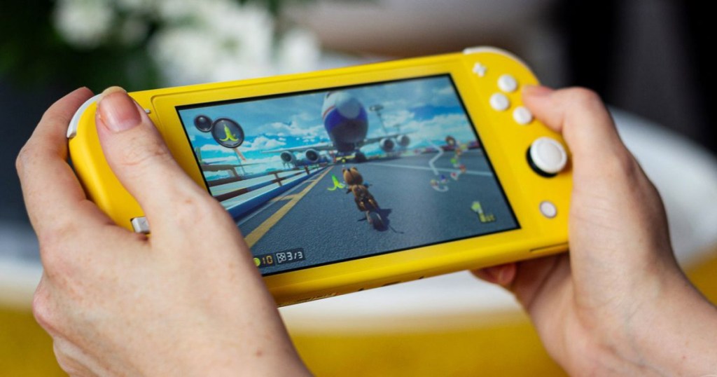 hands playing on yellow gaming console