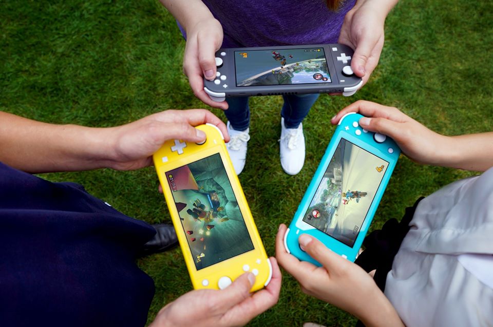 kids holding Nintendo Switch LIte consoles