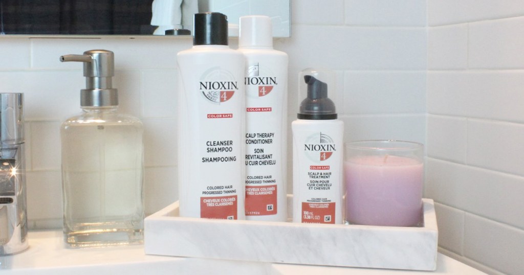 nioxin shampoo and conditioner bottles sitting in marble tray on bathroom counter