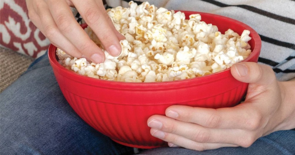 hand holding red popcorn bowl