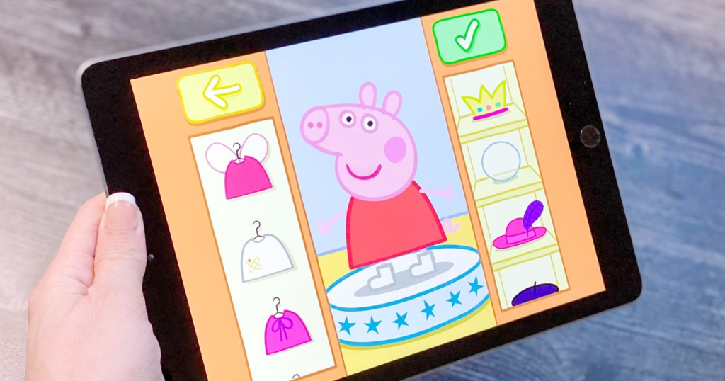 woman holding black ipad playing app dressing up peppa pig