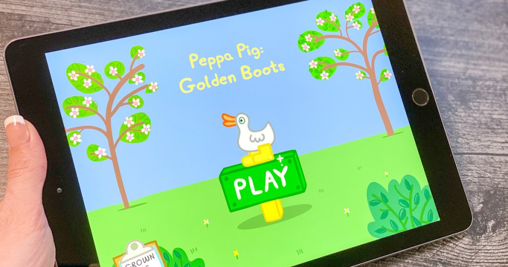 woman holding black ipad playing peppa pig golden boots game