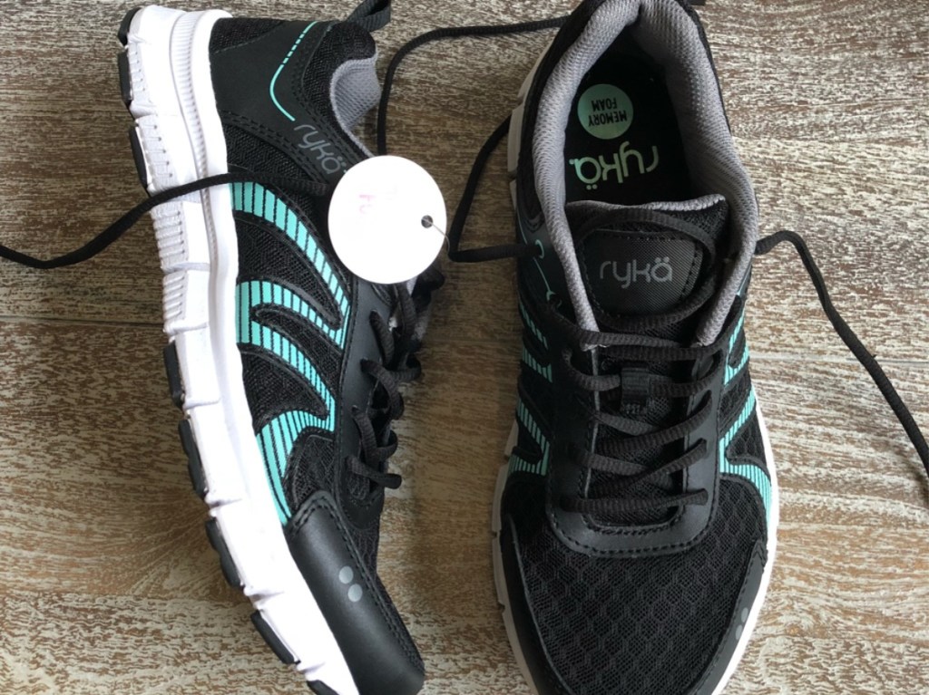 black and blue women's running shoes on floor