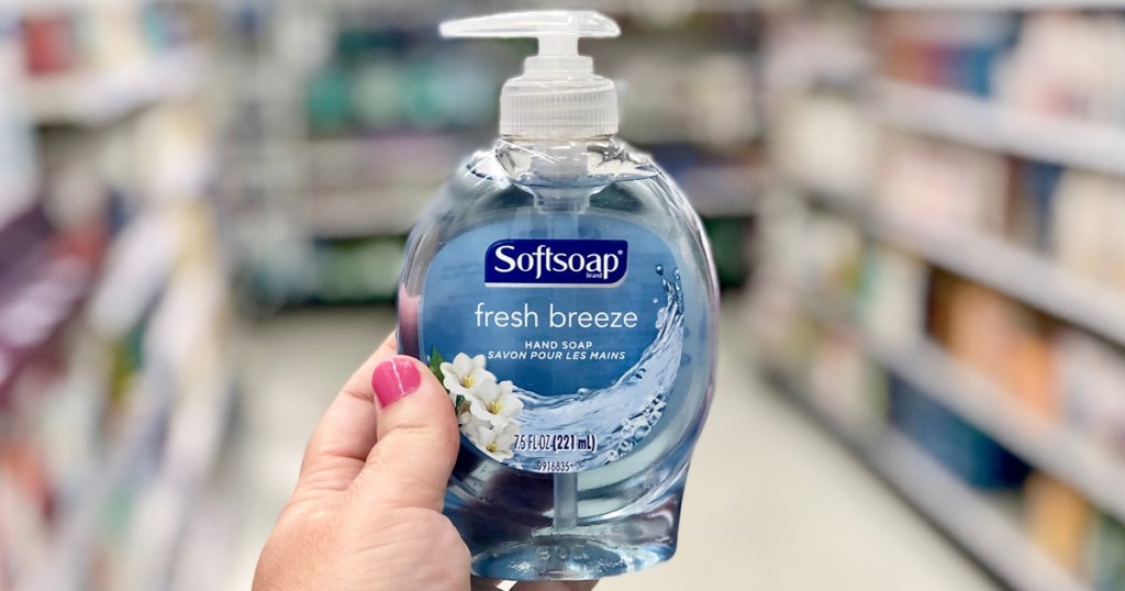 woman with pink nails holding up a bottle of softsoap brand hand soap in light blue bottle