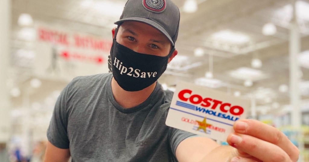 man wearing face mask in store holding Costco membership card