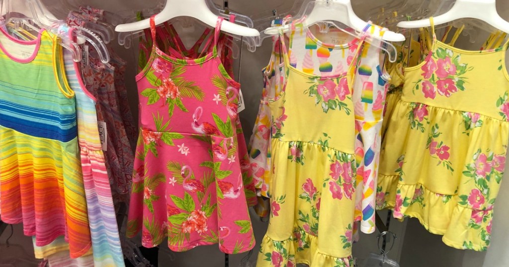 girls striped and floral dresses hanging in a store