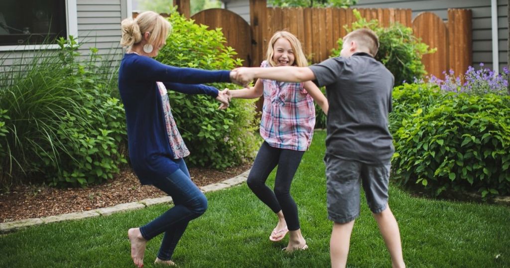 Mom dancing with her kids in the backyard