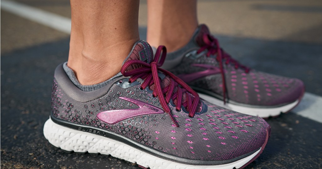 woman in purple and grey running shoe on pavement