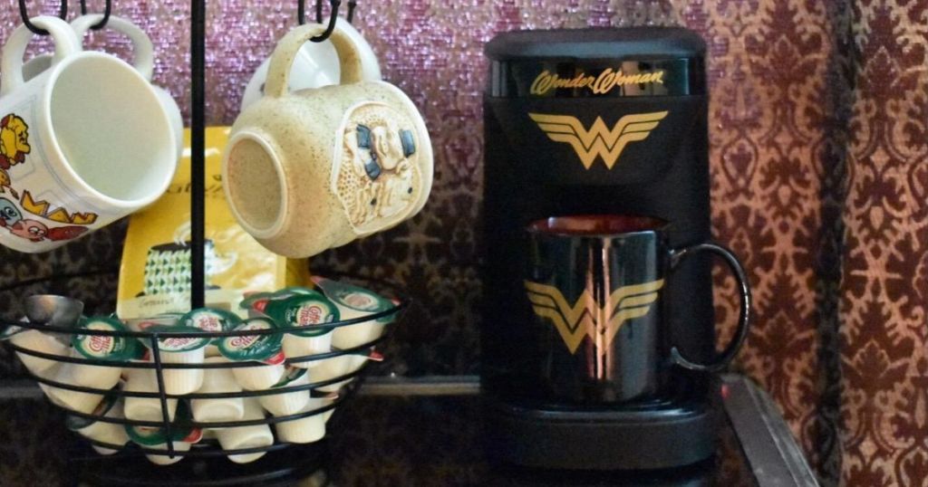 wonder woman coffee maker next to mug rack with creamers