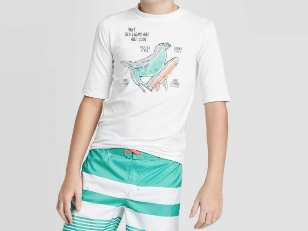 boy wearing swim shorts and shirt