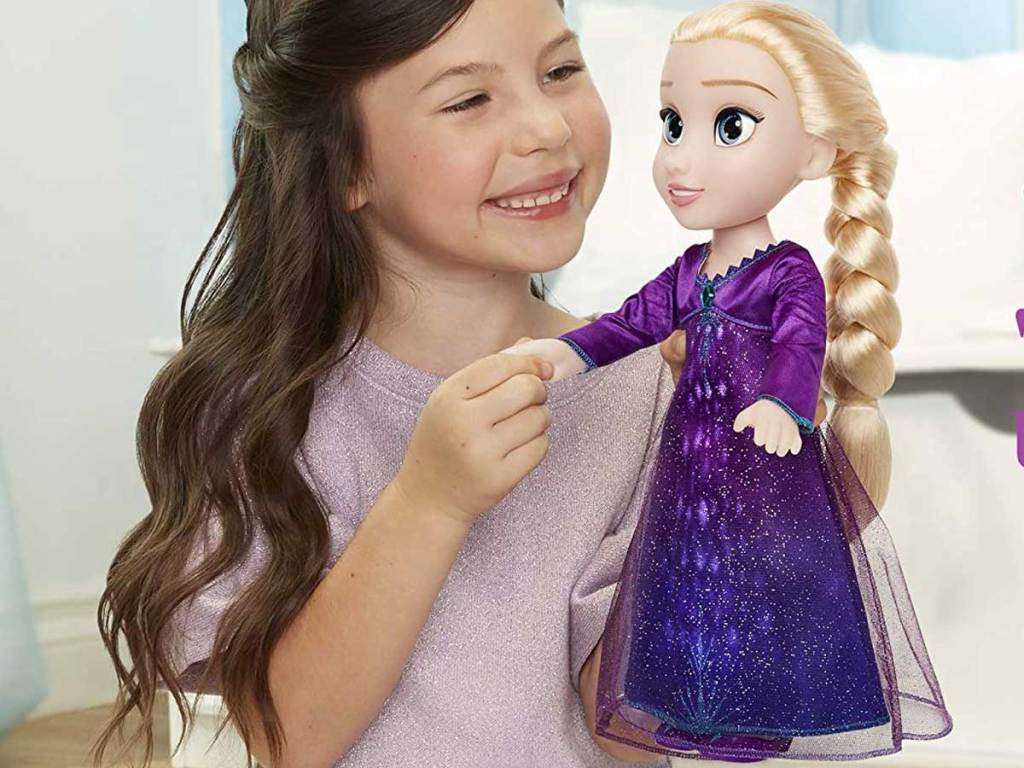 little girl holding Disney Frozen 2 Into The Unknown Singing Feature Elsa Doll