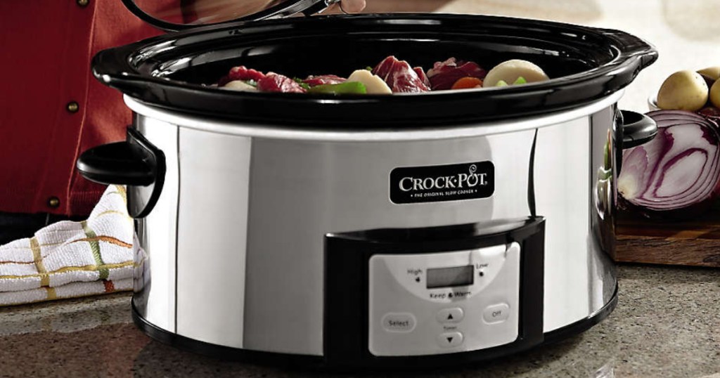 stainless steel slow cooker filled with food on kitchen counter